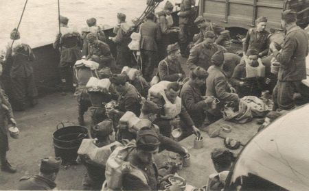 Truppe trasportate a bordo del Piroscafo Ogaden, nel marzo 1942, Mare Tirreno. Durante il rancio; si intravedono anche dei veicoli. Collezione Croci